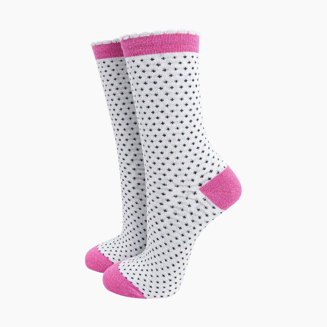 White socks with black polka dots and pink accents on a white background