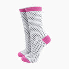 White socks with black polka dots and pink accents on a white background